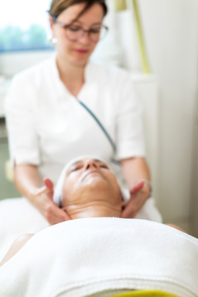 一位安详的女士在一家健康中心接受头部按摩图片下载