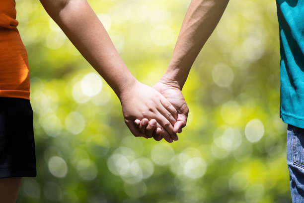 男人和女人牵着模糊的绿色自然背景图片下载