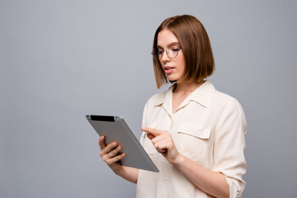 近距离的侧面资料照片美丽迷人的她她的商务女士首席电子阅读器手手臂阅读器数据初创新奇感兴趣好奇穿眼镜休闲白衬衫孤立的灰色背景图片下载