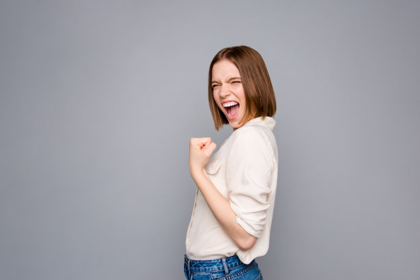 迷人的可爱的女士的肖像举起拳头耶感觉坦率的尖叫内容穿着时尚的衬衫现代愉快孤立的灰色银色背景图片下载