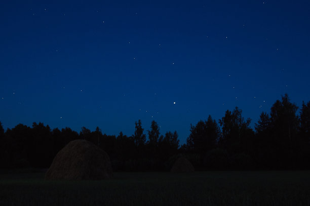 晚上在森林附近的田野上干草堆图片下载