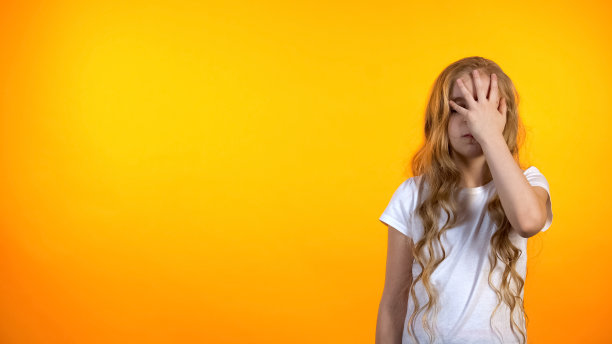 有趣的女学生对作业不高兴做捂脸的手势，疲惫的孩子图片下载