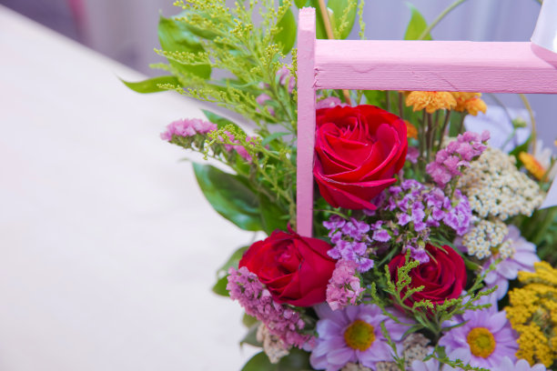 一束彩色玫瑰。红的、紫色的花朵图片近距离在花束中。丝带。一束鲜紫色、红色、粉红色、白色、蓝色、橙色的玫瑰。图片下载