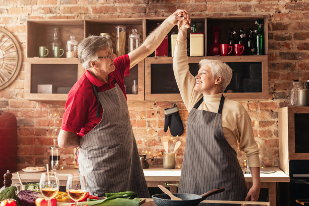 漂亮的高年级情侣在厨房跳舞图片下载