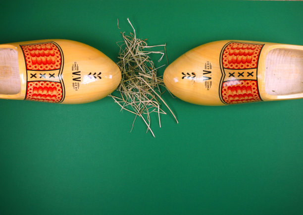 传统的荷兰木屐与干草隔离在绿色背景与复制空间为您自己的文本图片下载