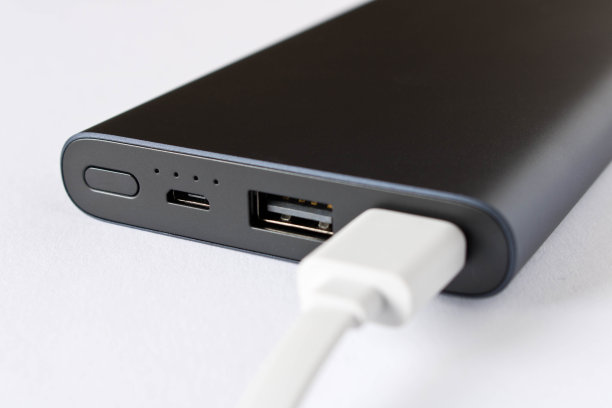 配有适配器的黑色电源银行，可在白色背景下为移动设备充电。图片下载