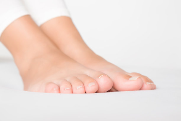 年轻，完美，干净女人的脚在床上放松。特写镜头。图片下载