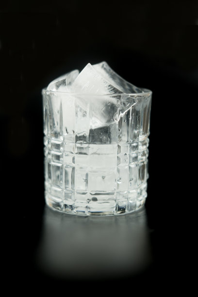 黑色背景上的空杯子里的冰块。图片下载