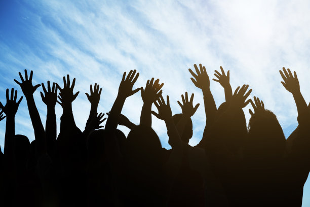 一群人在蓝天下举起双手图片下载