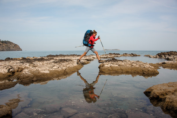 在海边背着背包徒步旅行的女人图片下载