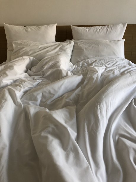 凌乱的床上有被子和枕头的照片图片下载