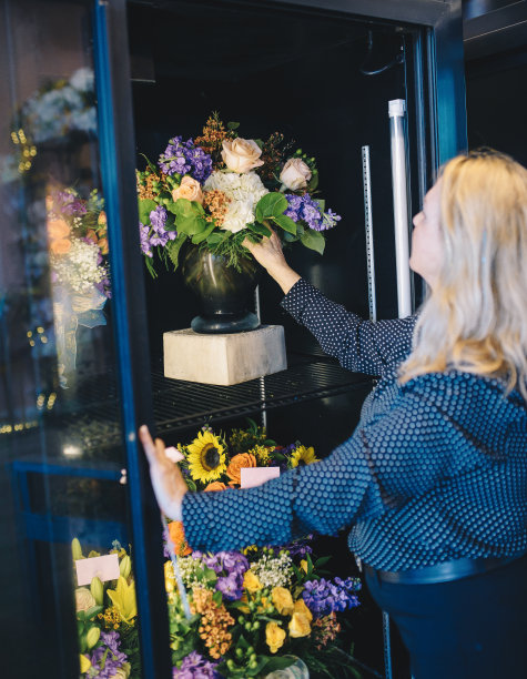 女花商60岁美丽的金发成熟的女人工作与花图片下载