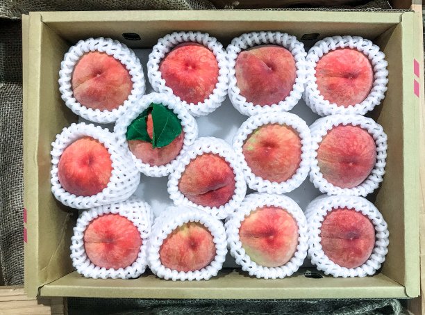 桃子用塑料网眼垫在纸板箱里图片下载