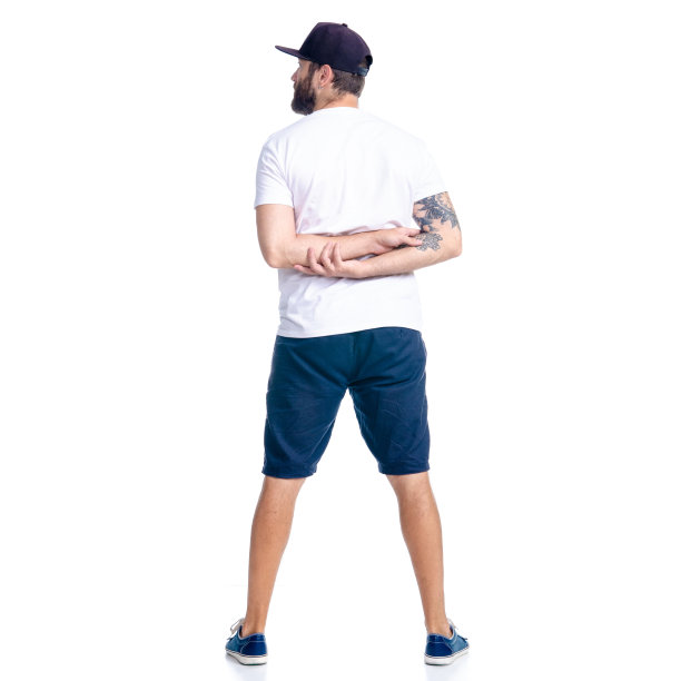 穿着短裤和帽子的男人站着看图片下载