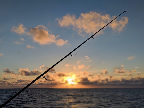 在海面上垂钓夕阳图片下载