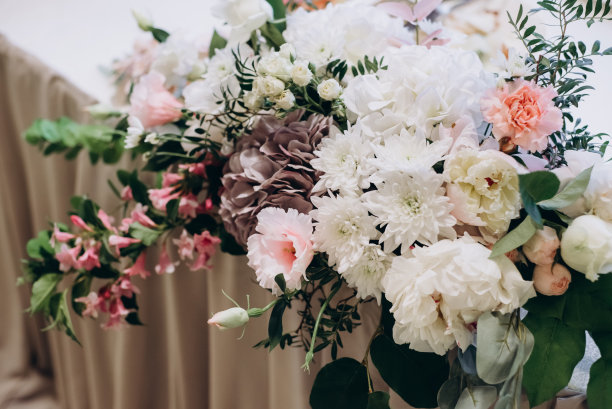 节日餐桌上美丽而时尚的白色和粉色花束的特写图片。图片下载