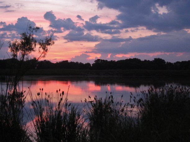 俄克拉何马州农场池塘上的彩色日落图片下载