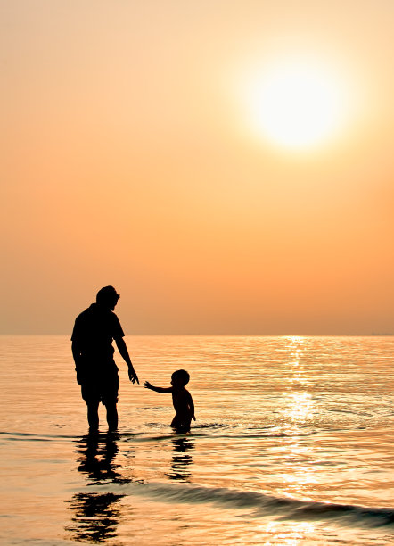 爸爸和儿子在海滩上玩。图片下载