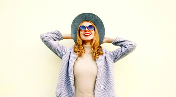 肖像特写快乐的年轻微笑的女人享受生活穿着粉红色的大衣，圆帽的背景图片下载