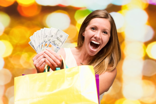 美丽的女人在散景的背景和持有现金图片下载