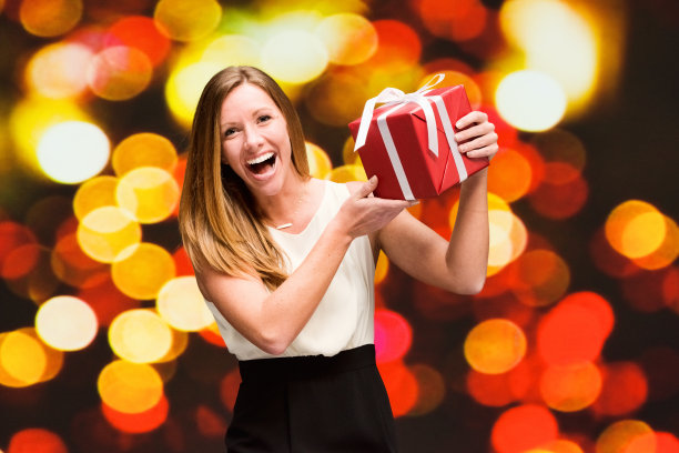 美丽的女人在散景背景拿着礼盒图片下载