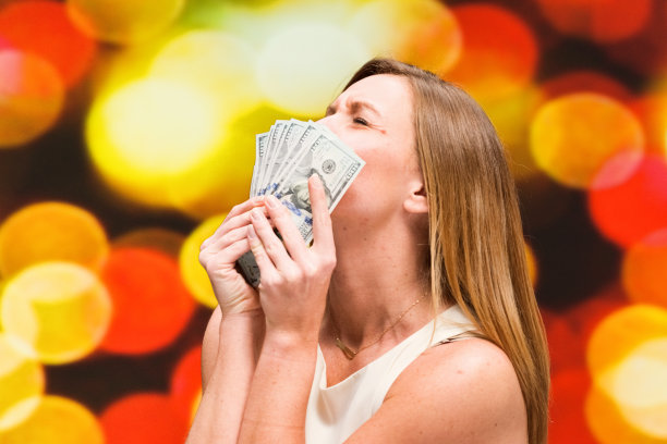 美丽的女人在散景的背景和持有现金图片下载