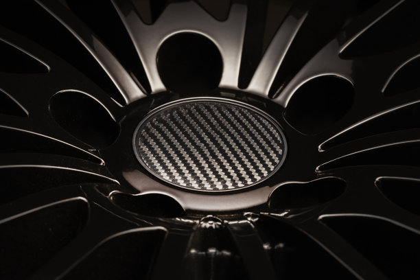 新的豪华黑色合金车轮，运动与薄辐条和碳帽，近距离上的黑色背景。图片下载