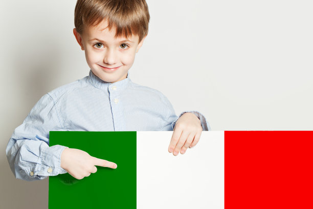 快乐的男孩拿着意大利国旗在白色的背景图片下载
