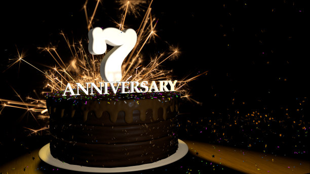 7周年贺卡。木质的桌子上放着巧克力蛋糕，上面装饰着彩色的糖霜和白色的数字，黑色的背景是烟花，星星落在桌子上。三维演示图片下载