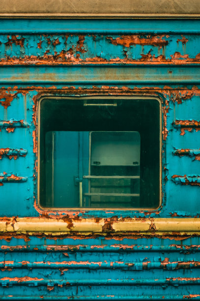 一辆被遗弃的苏联火车上生锈的蓝色车厢的窗户图片下载