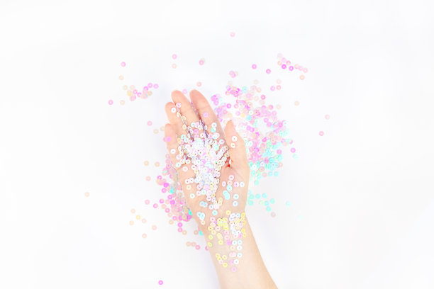 珍珠彩色纸屑点缀着女人的手图片下载