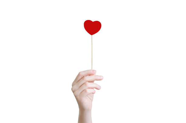 这个女孩手里拿着一根棍子，上面有一颗红心。特写镜头。白色隔离图片下载