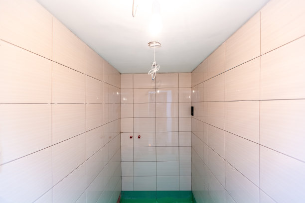 公寓浴室内墙面、地板采用绿色防水饰面材料瓷砖，正在施工、改造、翻新、大修、扩建、修复、改建中。家居改善的概念图片下载