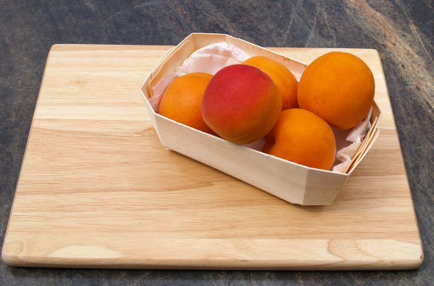 新鲜的杏子正准备放在木砧板上图片下载