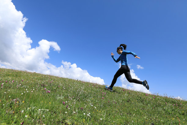 女子超长马拉松越野赛选手在草原山上奔跑图片下载