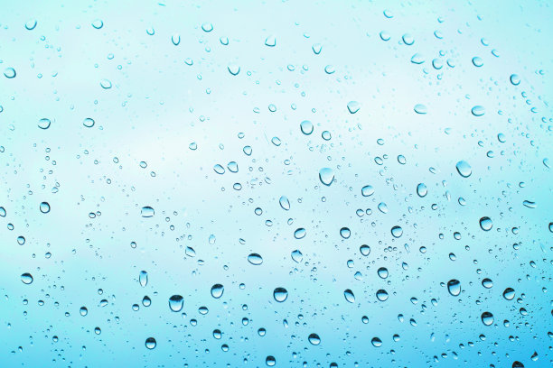 雨站在玻璃上。白色背景玻璃上的水滴图片下载