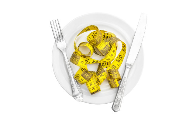 叉子用刀和卷尺放在盘子上。孤立在白色的。节食与健康饮食的概念。前视图。图片下载