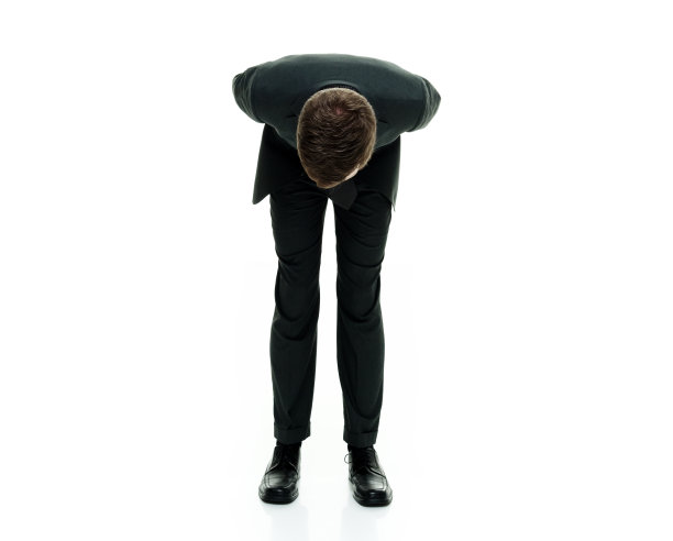 商人穿西装打领带，站在白色背景上鞠躬图片下载