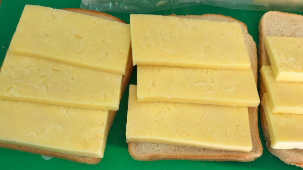 想象一下，在烤面包上自制奶酪，配上厚厚的陈年切达干酪和白面包，放在卫生的绿色塑料切菜板上，随时可以在烤架下烹饪和融化，成为不健康的饮食，美味的午餐零食图片下载