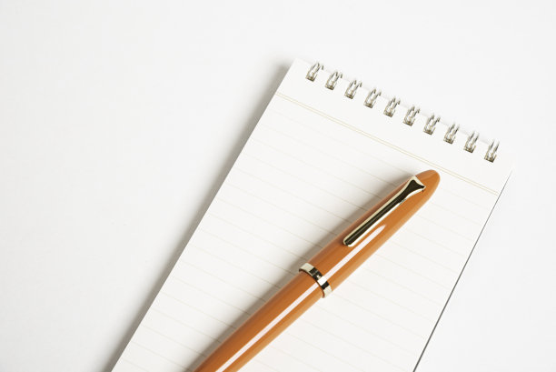 橙色钢笔和螺旋装订笔记本图片下载