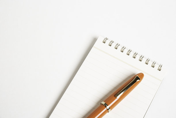 橙色钢笔和螺旋装订笔记本图片下载