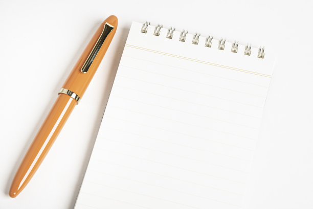 橙色钢笔和螺旋装订笔记本图片下载