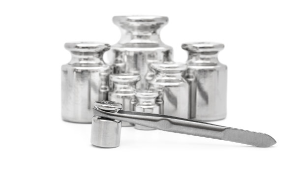 实验室用镊子秤的砝码在白色上。图片下载