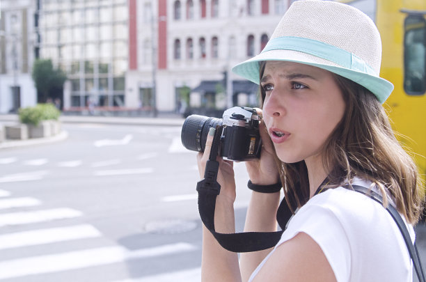 年轻的少女摄影师在城市街道的户外图片下载