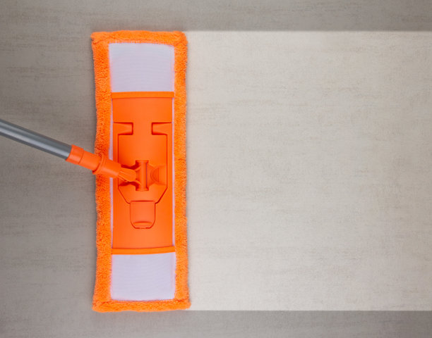 用橙色拖把清洁灰色陶瓷地板，用拷贝空间俯视图图片下载