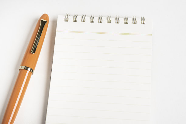 橙色钢笔和螺旋装订笔记本图片下载