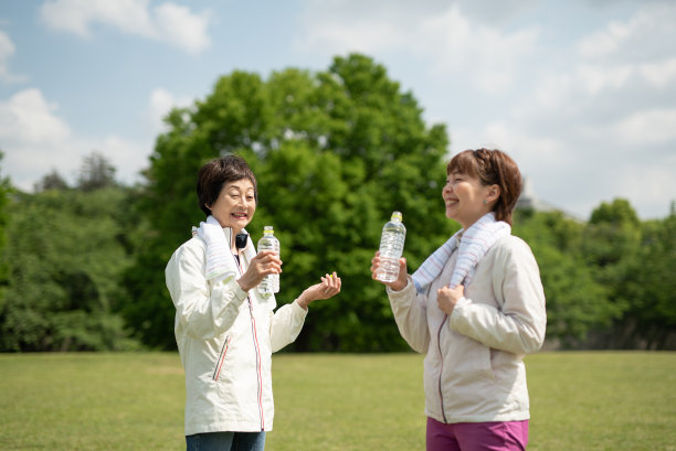 老女人和年轻女人在公园里喝瓶装水图片下载