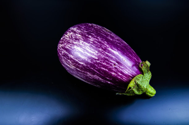 在黑色背景上的菜园蔬菜茄子。图片下载