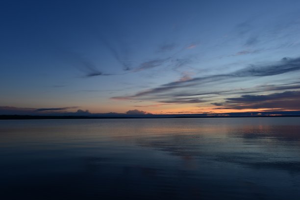 深蓝的天空在晚霞的微光中倒映在宁静的湖面上图片下载