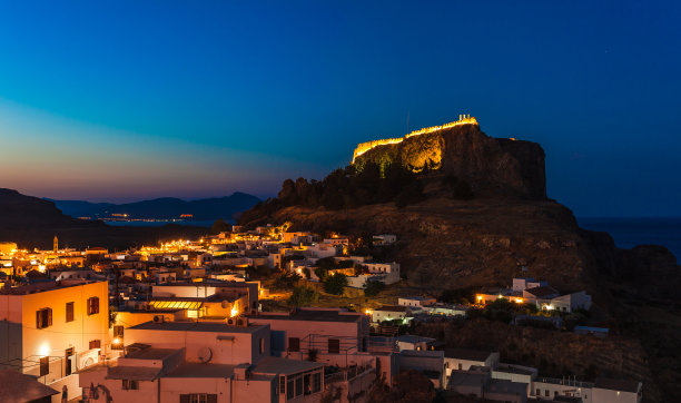 这是希腊罗得岛林多斯小镇和城堡的夜景照片。全景与明亮的灯光，山和海。是南欧著名的旅游胜地图片下载